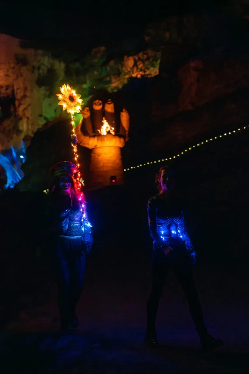 Festival performers with LED lights and sunflower staff